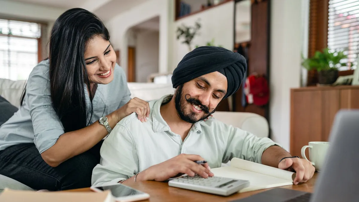 A couple reviewing paperwork together at a bright kitchen table