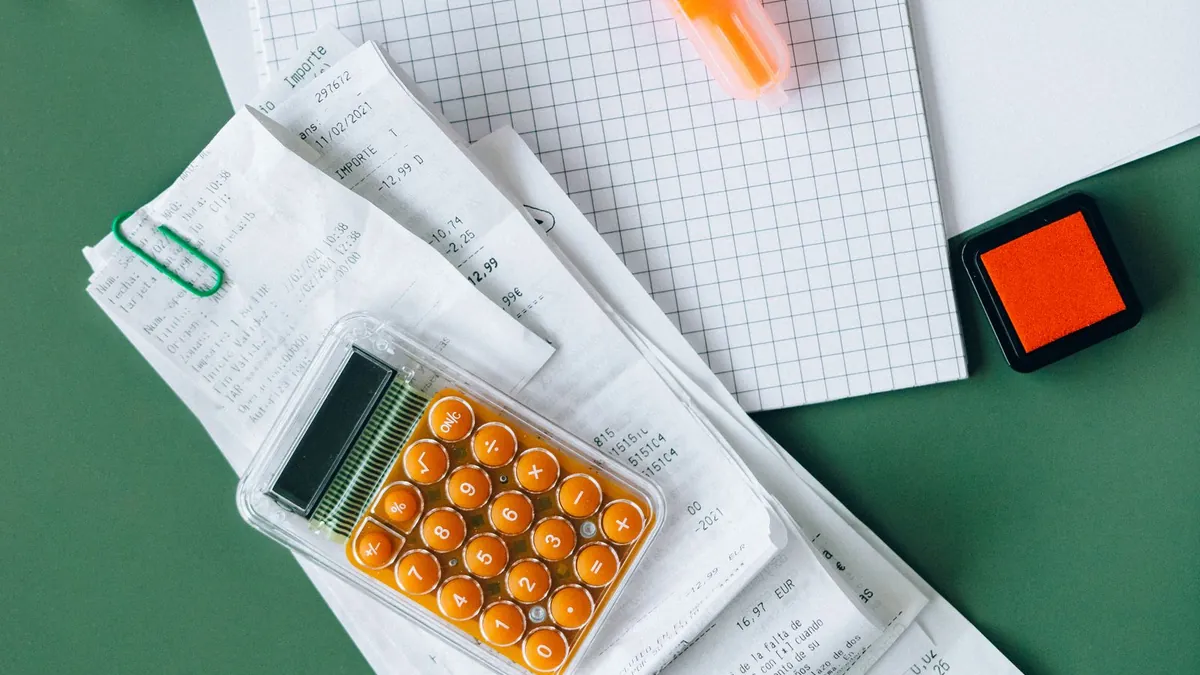 Tax forms, a calculator, and a pen arranged on a desk