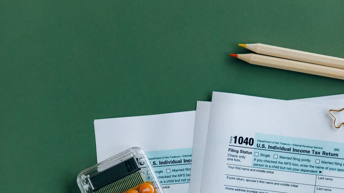 Tax documents, receipts, a pen, and calculator arranged for review