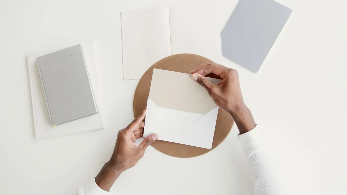 A person carefully opening an envelope containing an official-looking letter